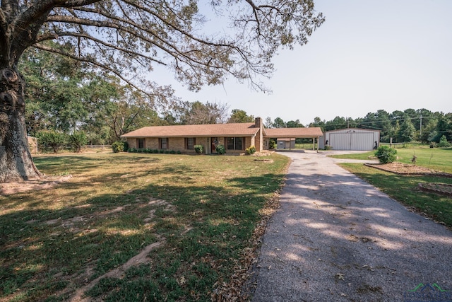 ranch-style house featuring an outbuilding and a front yard