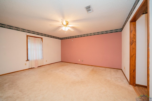 spare room featuring ceiling fan, a textured ceiling, and light carpet