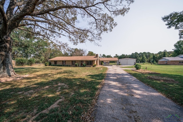 ranch-style house with a garage, an outdoor structure, and a front lawn