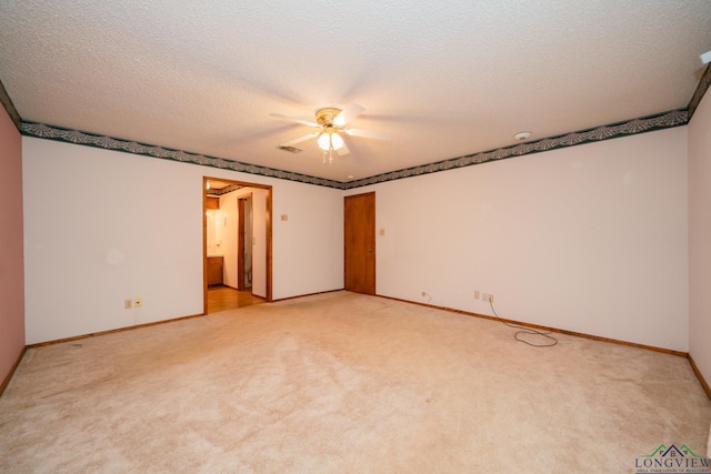 carpeted spare room featuring a textured ceiling and ceiling fan