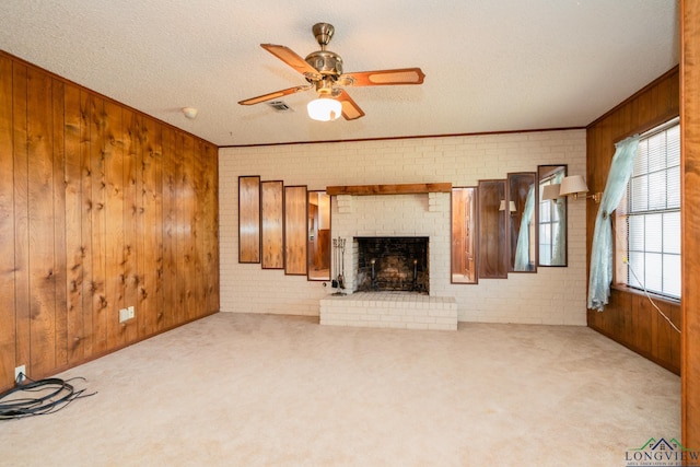 unfurnished living room featuring wood walls, plenty of natural light, and brick wall