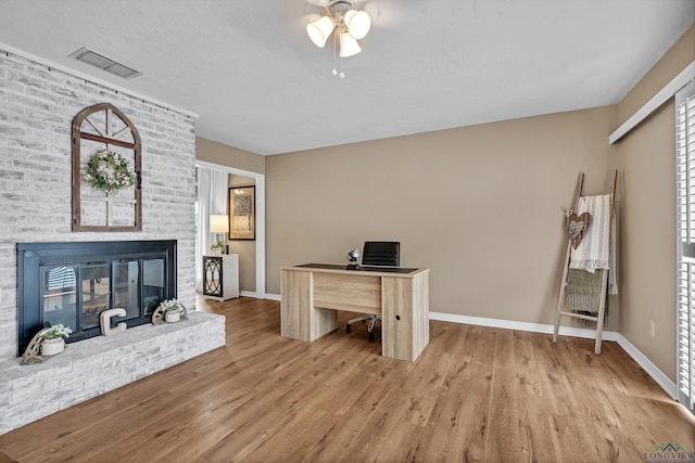 office area featuring a ceiling fan, baseboards, visible vents, and wood finished floors