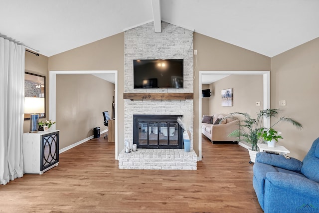 living room featuring a brick fireplace, beam ceiling, wood finished floors, baseboards, and high vaulted ceiling