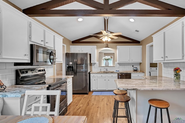 kitchen featuring decorative backsplash, vaulted ceiling with beams, stainless steel appliances, and white cabinets