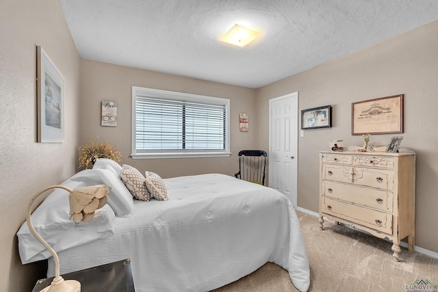 bedroom featuring baseboards, a textured ceiling, and light carpet