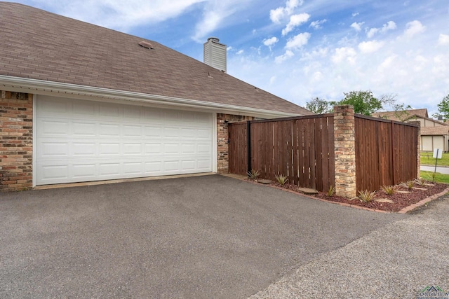 garage featuring fence and driveway