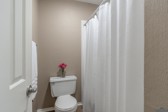full bath featuring toilet and curtained shower
