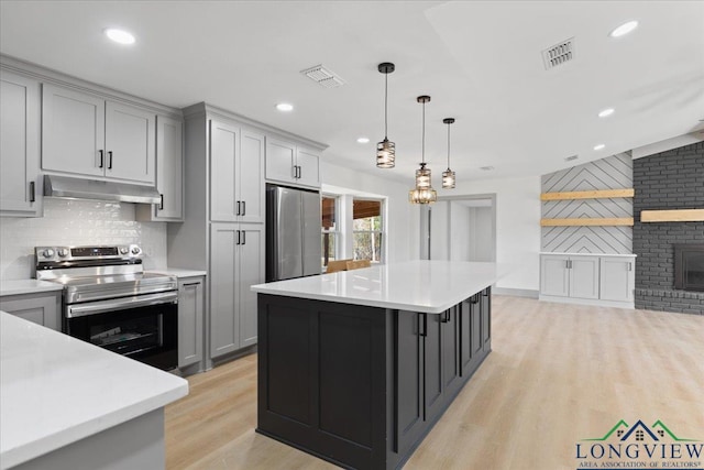 kitchen featuring under cabinet range hood, visible vents, stainless steel appliances, and light countertops