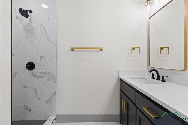 full bathroom featuring a tile shower, vanity, and baseboards