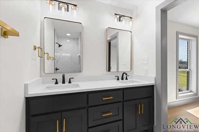 full bath with double vanity, a marble finish shower, and a sink