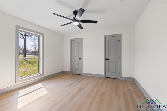 unfurnished bedroom featuring light wood-type flooring, ceiling fan, and baseboards