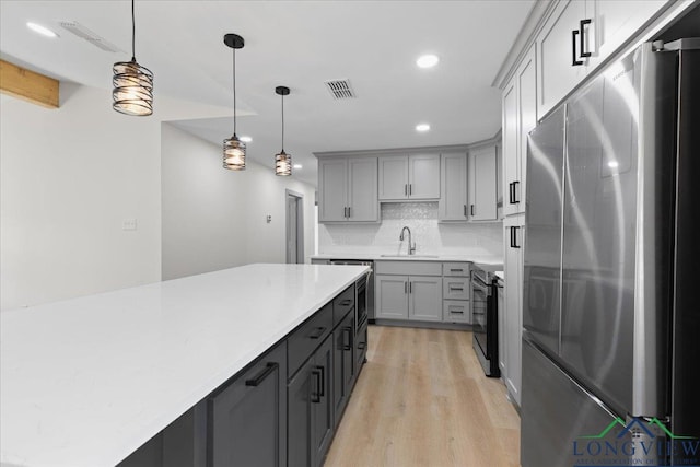 kitchen featuring visible vents, electric range, gray cabinets, and freestanding refrigerator