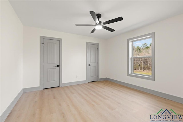 unfurnished bedroom with light wood-type flooring, a ceiling fan, and baseboards