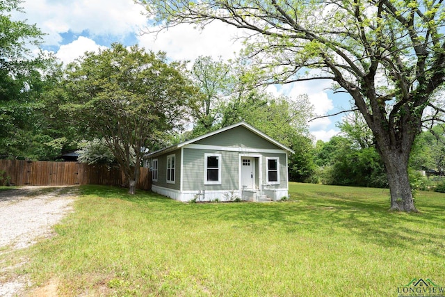 bungalow-style house featuring a front lawn and fence