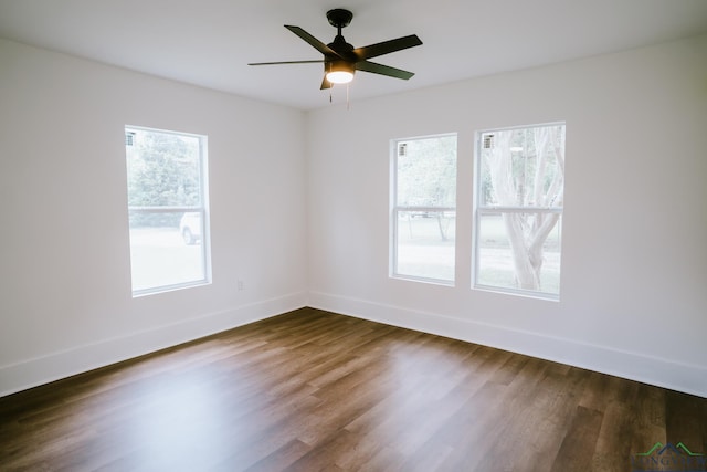 unfurnished room featuring a ceiling fan, baseboards, and dark wood-style flooring