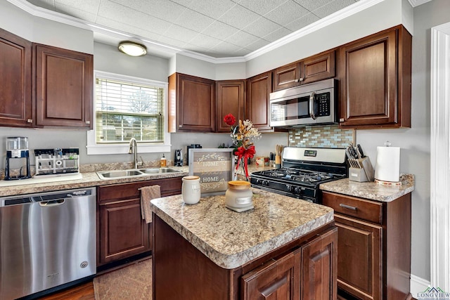 kitchen with tasteful backsplash, a kitchen island, stainless steel appliances, light countertops, and a sink