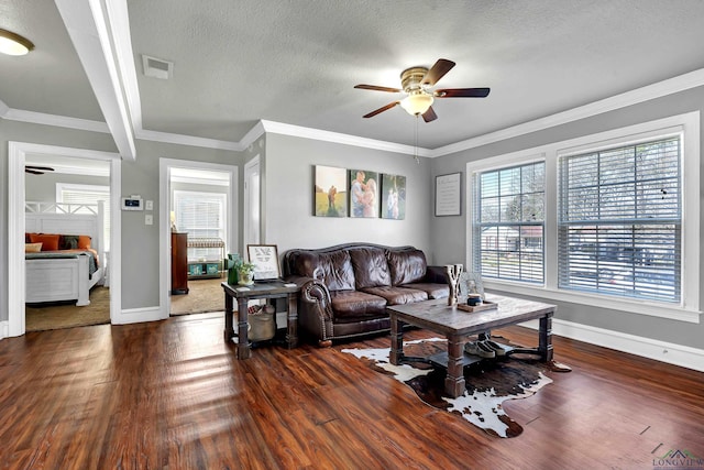 living area featuring a ceiling fan, a textured ceiling, visible vents, and wood finished floors