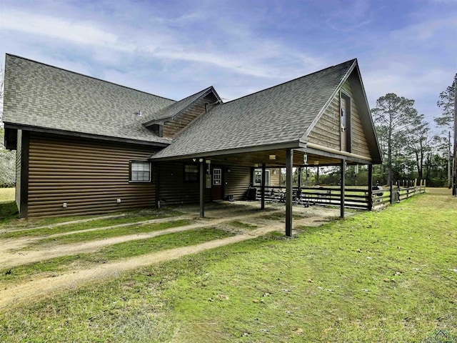 view of side of home with faux log siding and roof with shingles