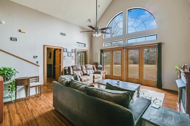 living area with ceiling fan, vaulted ceiling, light wood-type flooring, and visible vents