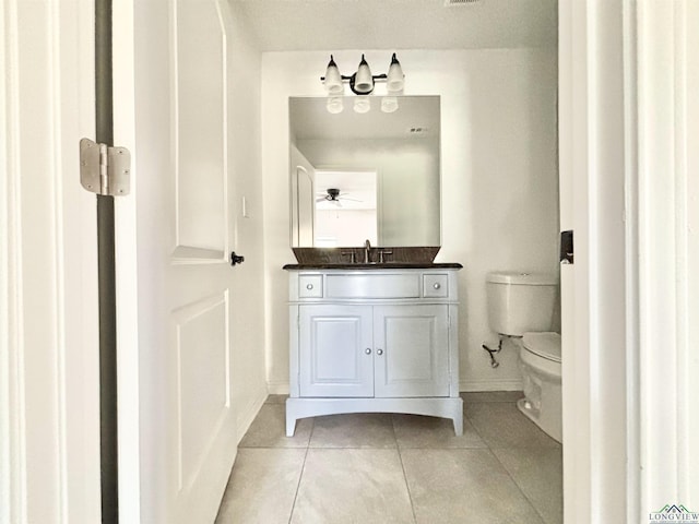 68 Eason Ln, Atlanta, TX 75551 - half bath with toilet, vanity, ceiling fan with notable chandelier, tile patterned flooring, and baseboards