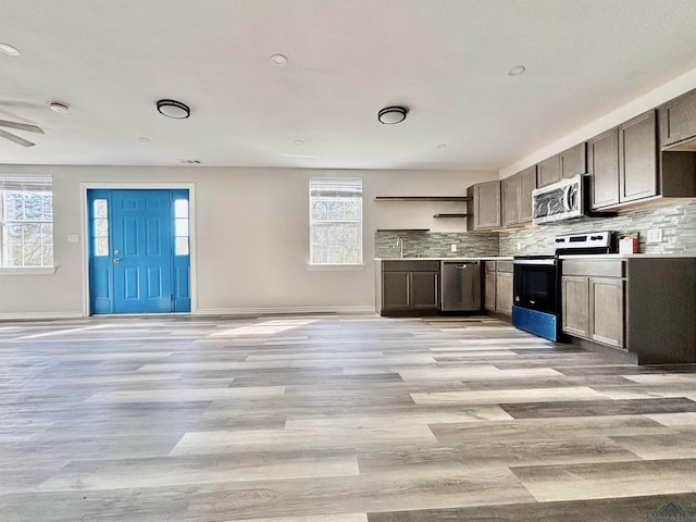 68 Eason Ln, Atlanta, TX 75551 - kitchen with light wood-type flooring, decorative backsplash, and stainless steel appliances