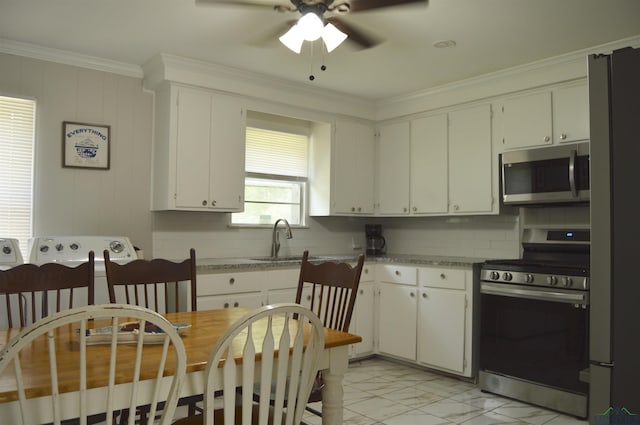 105 W Highland Ave, Longview, TX 75602 - kitchen with stainless steel appliances, a sink, ornamental molding, ceiling fan, and light marble finish flooring