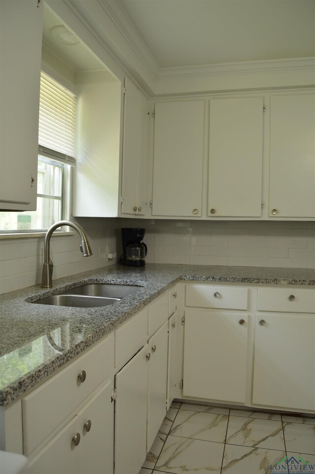 105 W Highland Ave, Longview, TX 75602 - kitchen with a sink, light marble finish floors, decorative backsplash, white cabinets, and light stone counters