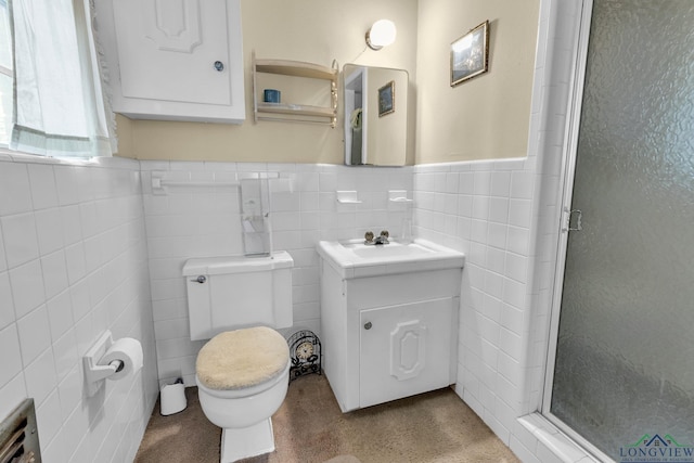 bathroom with toilet, tile walls, a shower stall, and a wainscoted wall
