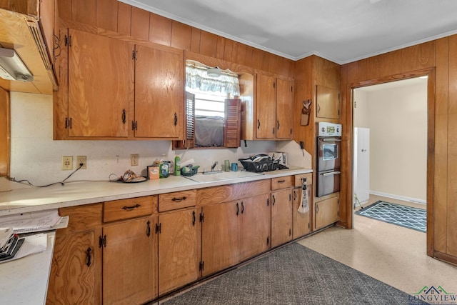 kitchen featuring crown molding, stainless steel oven, a warming drawer, light countertops, and a sink