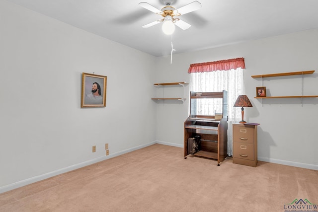 home office featuring light colored carpet, baseboards, and a ceiling fan
