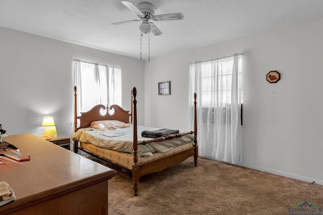 bedroom with baseboards, multiple windows, light colored carpet, and a ceiling fan