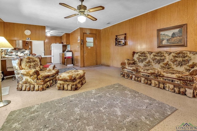 living area with wood walls and ceiling fan