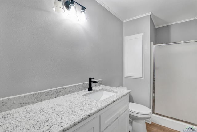 full bathroom featuring crown molding, toilet, a shower stall, vanity, and wood finished floors