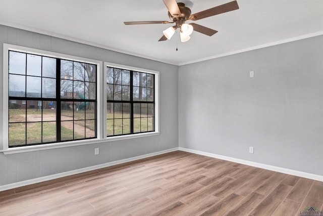 unfurnished room featuring crown molding, wood finished floors, a ceiling fan, and baseboards