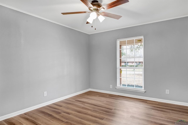 unfurnished room with crown molding, wood finished floors, and baseboards