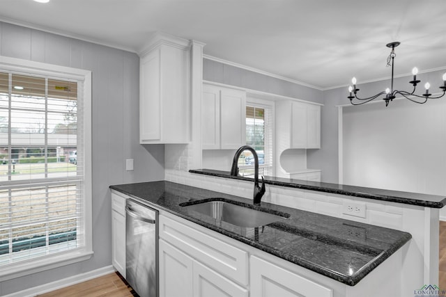 kitchen featuring white cabinets, dishwasher, crown molding, a chandelier, and a sink