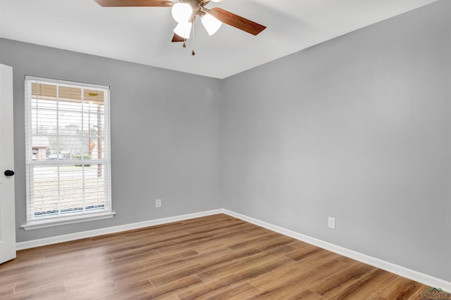 unfurnished room with ceiling fan, wood finished floors, and baseboards