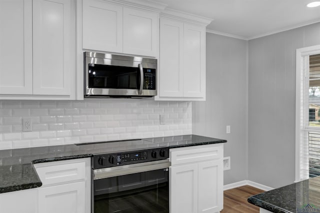 kitchen with wall oven, white cabinets, stainless steel microwave, ornamental molding, and wood finished floors