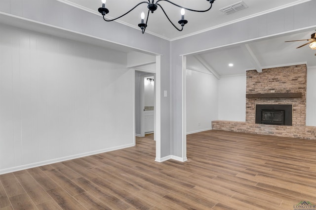 unfurnished living room with visible vents, ornamental molding, wood finished floors, a fireplace, and ceiling fan with notable chandelier