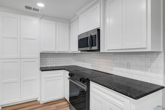 kitchen with visible vents, stainless steel microwave, light wood-style flooring, electric range, and white cabinetry