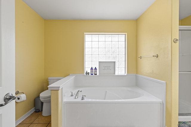 bathroom with tile patterned flooring, toilet, and a bath