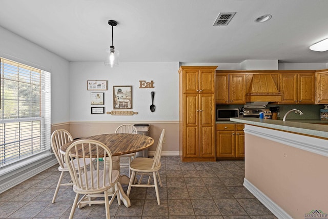 kitchen with decorative light fixtures and custom exhaust hood