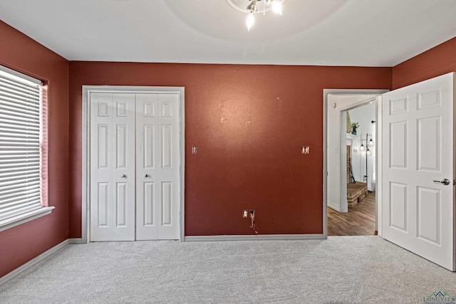 unfurnished bedroom featuring ceiling fan, a closet, and light colored carpet