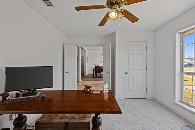 carpeted office space featuring ceiling fan