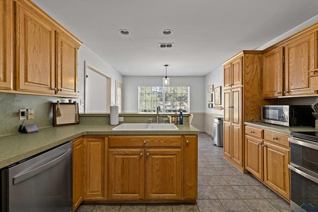 kitchen featuring kitchen peninsula, stainless steel appliances, sink, hanging light fixtures, and light tile patterned flooring