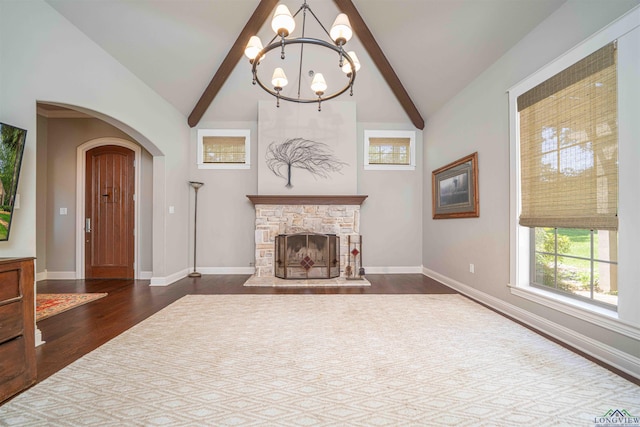 108 Fountainebleau Ave, Longview, TX 75605 - unfurnished living room with a chandelier, arched walkways, dark wood-type flooring, a fireplace, and baseboards