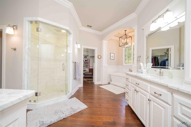 108 Fountainebleau Ave, Longview, TX 75605 - bathroom featuring a chandelier, ornamental molding, a stall shower, wood finished floors, and a spacious closet