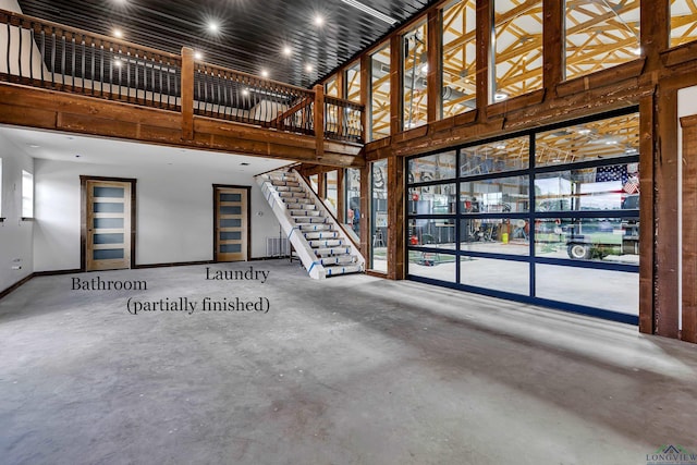 4300 Willow Bnd, Longview, TX 75602 - unfurnished living room featuring a high ceiling, concrete floors, stairway, and baseboards