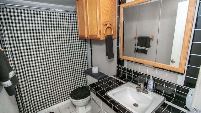 bathroom featuring toilet, crown molding, tile patterned floors, sink, and backsplash