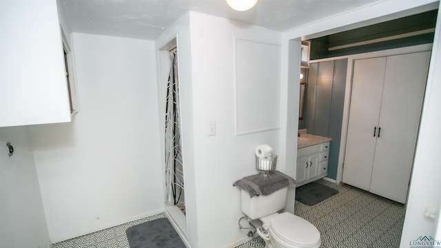 bathroom featuring walk in shower, vanity, and toilet